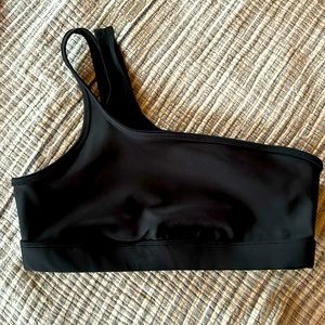Alo Yoga one-shoulder strap black sports bra with mesh lining.
